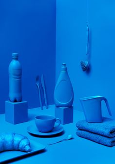 a blue room with dishes, cups and utensils on the table in front of it