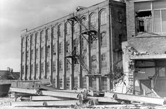 an old black and white photo of a building being demolished