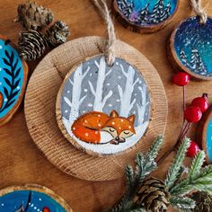 some ornaments that are on top of a wooden table with pine cones and other decorations