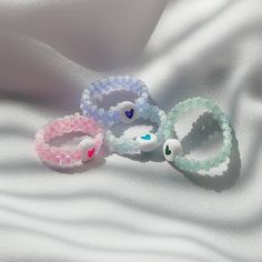 three beaded bracelets laying on top of a white sheet