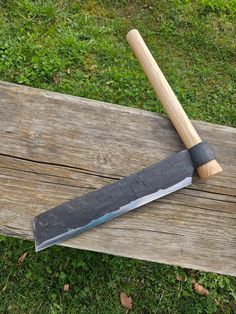 a large knife sitting on top of a wooden bench