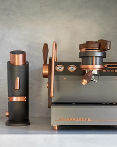 an espresso machine sitting on top of a counter next to a coffee grinder