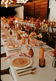 the table is set with plates, silverware and flowers