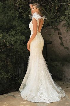 a woman in a wedding dress standing outside