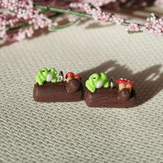 two small figurines sitting on top of a piece of chocolate