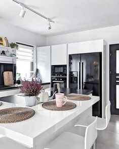 a kitchen with white counter tops and black appliances