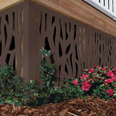 some pink flowers are growing on the side of a building with wood slats and trelliss