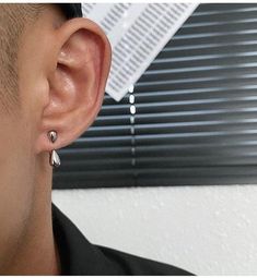 a close up of a person with ear piercings on their ears and wearing a black shirt