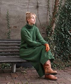 a woman sitting on top of a wooden bench