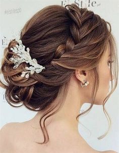 a woman with her hair in a low bun is wearing a white flower clip on her head