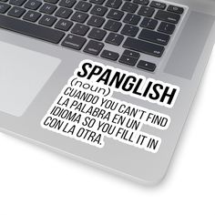 a laptop computer sitting on top of a white table next to a sticker that says spangliish