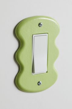 a green light switch cover on a white wall