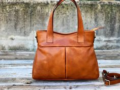 "This Brown cowhide leather bag is 100% handmade. this large tote bag is suitable for carrying everything in your everyday life. It has a Zipper Closure and Cross-Body strap. The bag has a cotton lining and it has 3 inner pockets. as you can see it made by really high-quality Italian leather.this leather calls \"Pelle Conciata Al Vegetale\", which means that the leather is tanned with only natural materials. Dimentions: - Width ( top of the bag ) : 32 Cm / 12.5'' ( Bottom of the bag ) : 37 Cm / Everyday Vegetable Tanned Leather Tote Bag, Everyday Vegetable Tanned Leather Shoulder Bag With Double Handle, Everyday Double Handle Vegetable Tanned Leather Shoulder Bag, Vegetable Tanned Leather Satchel For On-the-go, Vegetable Tanned Leather Tote Shoulder Bag For Everyday, Vegetable Tanned Leather Tote Shoulder Bag For Travel, Vegetable Tanned Leather Travel Tote Shoulder Bag, Vegetable Tanned Leather Tote Shoulder Bag, Everyday Vegetable Tanned Leather Tote Shoulder Bag