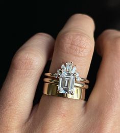 a woman's hand with a ring on it and an emerald stone in the middle