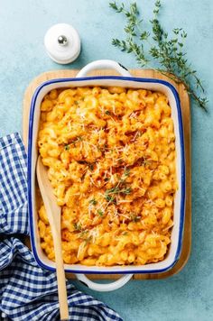 macaroni and cheese in a blue dish with a wooden spoon next to it