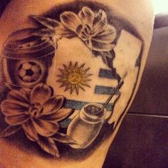 a tattoo on the back of a woman's leg with flowers and soccer ball