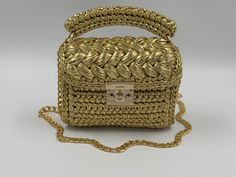 This special bag is knitted with metallic yarn. **It is 100% hand knitted. **It is lined inside and very spacious inside. **A lining of the appropriate color is sewn into the handmade metallic shoulder bag. **It will complete your elegance with your day or night outfits. This Bag is dimension ; 20*17*8 Note: It is not suitable for machine washing. Measurements may differ by 1-2 cm depending on the condition of the rope. Please contact me for different sizes and clours. Be sure to check out my ot Luxury Handmade Straw Bag, Gold Woven Top Handle Straw Bag, Luxury Gold Straw Bag With Braided Handles, Handwoven Gold Rectangular Straw Bag, Handwoven Rectangular Gold Straw Bag, Luxury Gold Woven Bag, Luxury Gold Straw Bag, Handmade Gold Shoulder Bag For Daily Use, Gold Rectangular Crochet Bag With Braided Handles