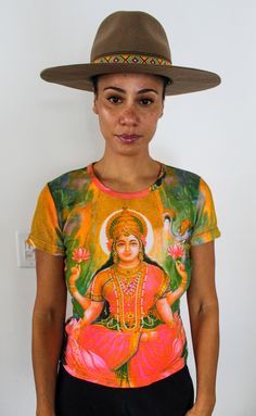 a woman wearing a hat and t - shirt with an image of the hindu god