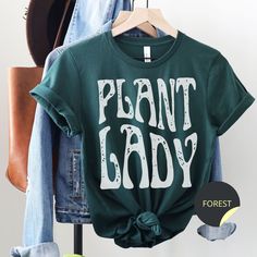 Retro Plant Shirt, Plant Lady Tee, Plant Mama TShirt, Gardener Gift, Plant Lover, Plant Mom Crewneck, Monstera Mom Tee, Plant Crew, Botanical These super soft Bella Canvas tees are unisex sizing.  Please double check the measurements provided in the listing before selecting a size.  If you are not certain of your size, try laying out your favorite t-shirt and measuring the length and bust, and then compare those measurements to the ones provided in the listing.   The tees are 65% polyester/ 35% cotton blend.  All shirts are made using Direct to Garment printing, which means ink is heat pressed into the shirt.  The image will never peel off, but DTG printing gives apparel a worn-in, vintage look.   ◆ CARE INSTRUCTION Turn garment inside out Machine wash cold with similar colors Use mild det Plant Shirts, Plant Mama, Mom Crewneck, Mama Tshirts, Trendy Shirt Designs, Gardening Shirts, Bella Canvas Tees, Botanical Drawings, Plant Mom