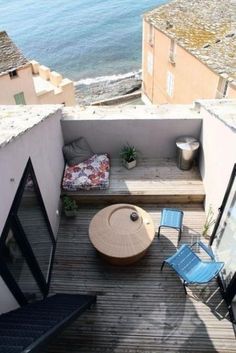 small balcony with table and chairs overlooking the ocean