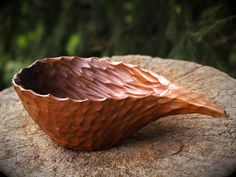 a wooden bowl sitting on top of a rock