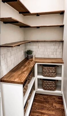 an empty pantry with wooden shelves and baskets