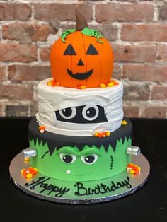 a three tiered halloween cake with pumpkins on top