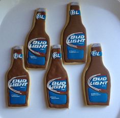 four bud light cookies on a white plate