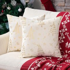 two christmas pillows sitting on top of a couch