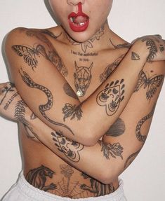 a woman with tattoos and piercings on her chest