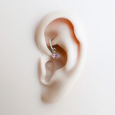 an ear is shown with a single diamond in it