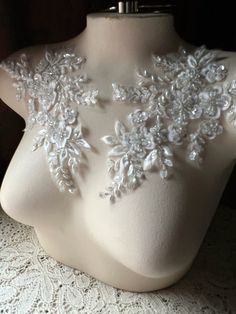 a mannequin with white lace and flowers on it