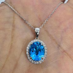 Beautiful Blue topaz and diamond necklace.  The color of this oval cut topaz is a gorgeous blue, not too light and not too dark.  It is surrounded by a nice halo of sparkling diamonds.  Lays nicely on the neck, won't flip around. The pendant measures from top of bail down about 22.2 x 12.5mm.  Chain shown is available for purchase separately. Great necklace for everyday wear.   Genuine blue topaz about 10.8 x 8.5mm Oval cut 4.20 Carats Genuine round brilliant cut diamonds  0.25 Carats  White and Blue Topaz Oval Necklace, Necklace For Everyday, Gold Gift Boxes, Blue Topaz Necklace, Oval Necklace, Blue Topaz Pendant, Topaz Pendant, Topaz Necklace, Jewelry Business