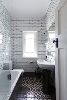 a white toilet sitting inside of a bathroom next to a blue and white area rug