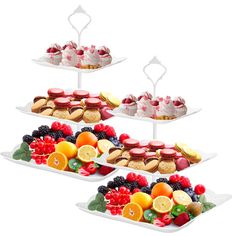 three trays filled with different types of desserts on top of each other,