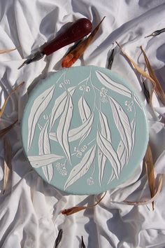 a white and blue plate sitting on top of a bed covered in grass next to scissors