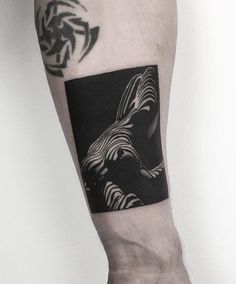 a man's arm with a black and white tattoo design on the left forearm