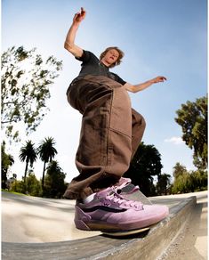 a man riding a skateboard up the side of a cement ramp with his feet in the air