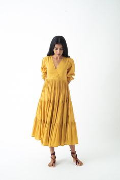 Experience freedom in our loose, tiered boho dress made from 100% organic cotton.  The open V-neck combined with the tiered skirt makes it perfect for beach strolls and summer dinners.  Features two inseam pockets and customizable colour options.  Length: 48 inches.  Quality: 60's Organic Cotton.  Care: Hand wash with light detergent or dry clean.  Ships within 3-5 business days. For quicker delivery please send us a message. Additional Information: Colour: Jaisalmer Mustard (Customizable to you Beach Tiered Cotton Dress With Ruffle Hem, Cotton Tiered Dress With Ruffle Hem For Beach, Flowy Bohemian Tiered Dress, Flowy Tiered Cotton Dress With Ruffle Hem, Peasant Style Tiered Skirt Summer Dress, Bohemian Cotton Tiered Maxi Dress, Bohemian Cotton Maxi Dress With Tiered Design, Tiered Cotton Maxi Dress With Ruffle Hem, Casual Cotton Tiered Maxi Dress