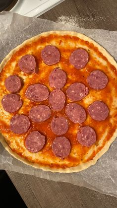 a pizza sitting on top of a table covered in cheese and pepperoni toppings