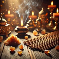 a candle and some rocks on a wooden table with candles in the background, surrounded by other items