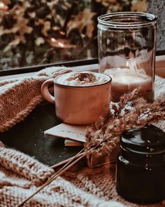 a glass jar sitting on top of a table next to a cup