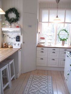 a kitchen with white cabinets and wooden floors