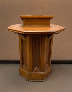 an old wooden table with a clock on it's top and side panel at the bottom