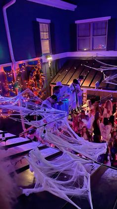 a group of people dressed up in halloween costumes standing on a porch with spider webs