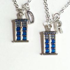 two necklaces that have the doctor who logo on them and are attached to chains