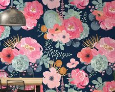 a floral wallpaper with pink flowers and green leaves on a dark blue background in a dining room