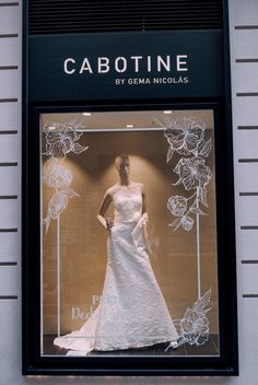 a window display featuring a white wedding dress