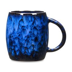 a blue and black coffee cup sitting on top of a table