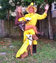 two people in costumes are posing for a photo with their dog and cat costumed up